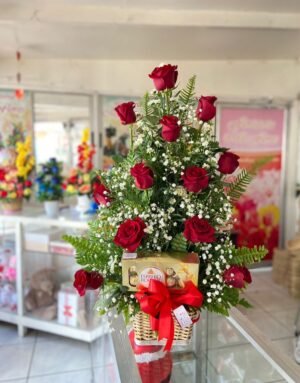 Arreglo de 12 rosas rojas con 8 ferreros en caja en canasta.